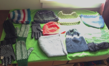 Knitted hats and mittens, plus a couple non-woolen gloves, drying in the sun. 